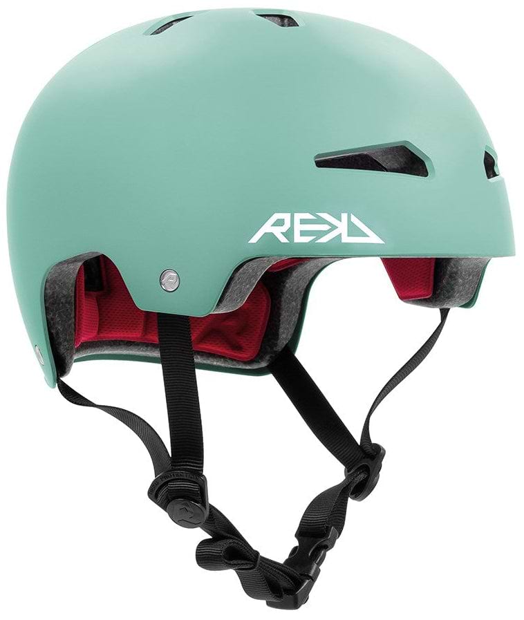 The REKD Elite 2.0 Skate/Scooter Helmet in matt teal features black ventilation slits, a white "REKD" logo, red interior padding, and adjustable black straps with buckle for a secure fit.