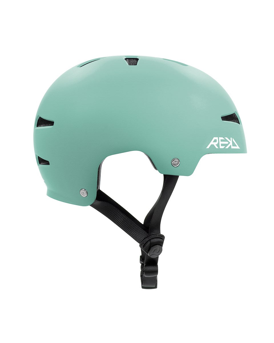 The REKD Elite 2.0 Skate/Scooter Helmet in matt teal features a black adjustable chin strap, multiple ventilation slots, and a white "REKD" logo on the side. Shown in side profile against a plain white background.