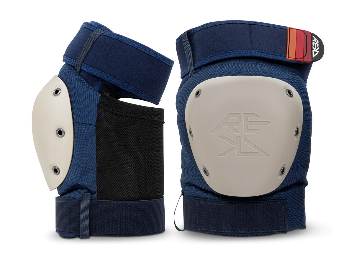 Two blue REKD Shield knee pads with beige protective caps and black side panels, displayed against a white background. One pad displays the front, while the other shows the side and fastening straps—an essential part of the REKD Shield Triple Skate Protection Pad Set - Blue, providing comprehensive action sport protection.