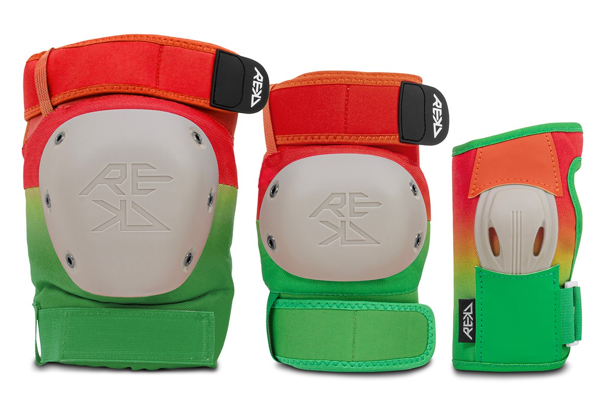 Three vibrant protective gear pieces—a pair of knee pads and one wrist guard—displayed upright. The REKD Shield Triple Skate Protection Pad Set in Fade Orange/Green features a striking blend of red, orange, yellow, and green accents complemented by white hard shells and black REKD-branded straps. This triple pad set from REKD offers maximum coverage and includes durable wrist guards, making it perfect for your next action sport adventure.