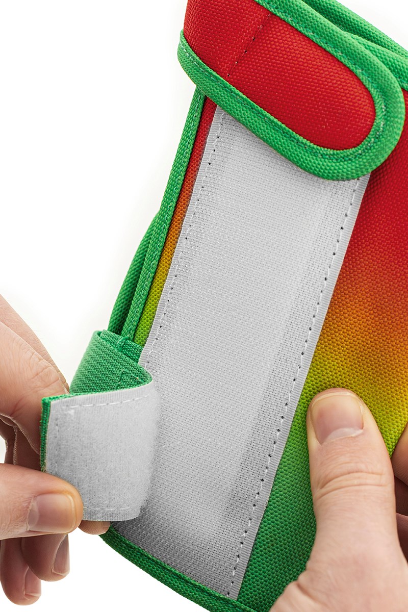Close-up of hands opening the REKD Shield Triple Skate Protection Pad Set pouch by REKD, featuring a vibrant fade orange and green exterior with a Velcro fastener—perfect for storing your wrist guards or other action sport protection gear.