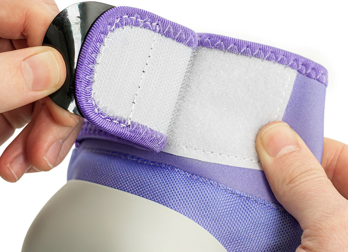 Close-up of hands fastening a purple and white Velcro strap on a shoe or boot, highlighting the textured fabric and secure closure—perfect to pair with the REKD Shield Triple Skate Protection Pad Set in Fade Red / Violet by REKD for comprehensive action sport protection.