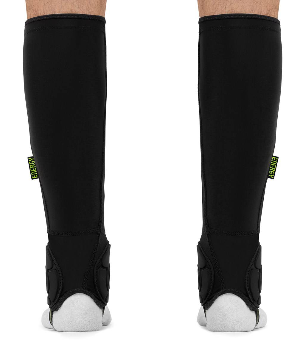 Black REKD Energy Covert Long Shin and Ankle Skate Protection Guards worn on the lower legs, featuring a small “ENERGY” tag on the side of each guard.