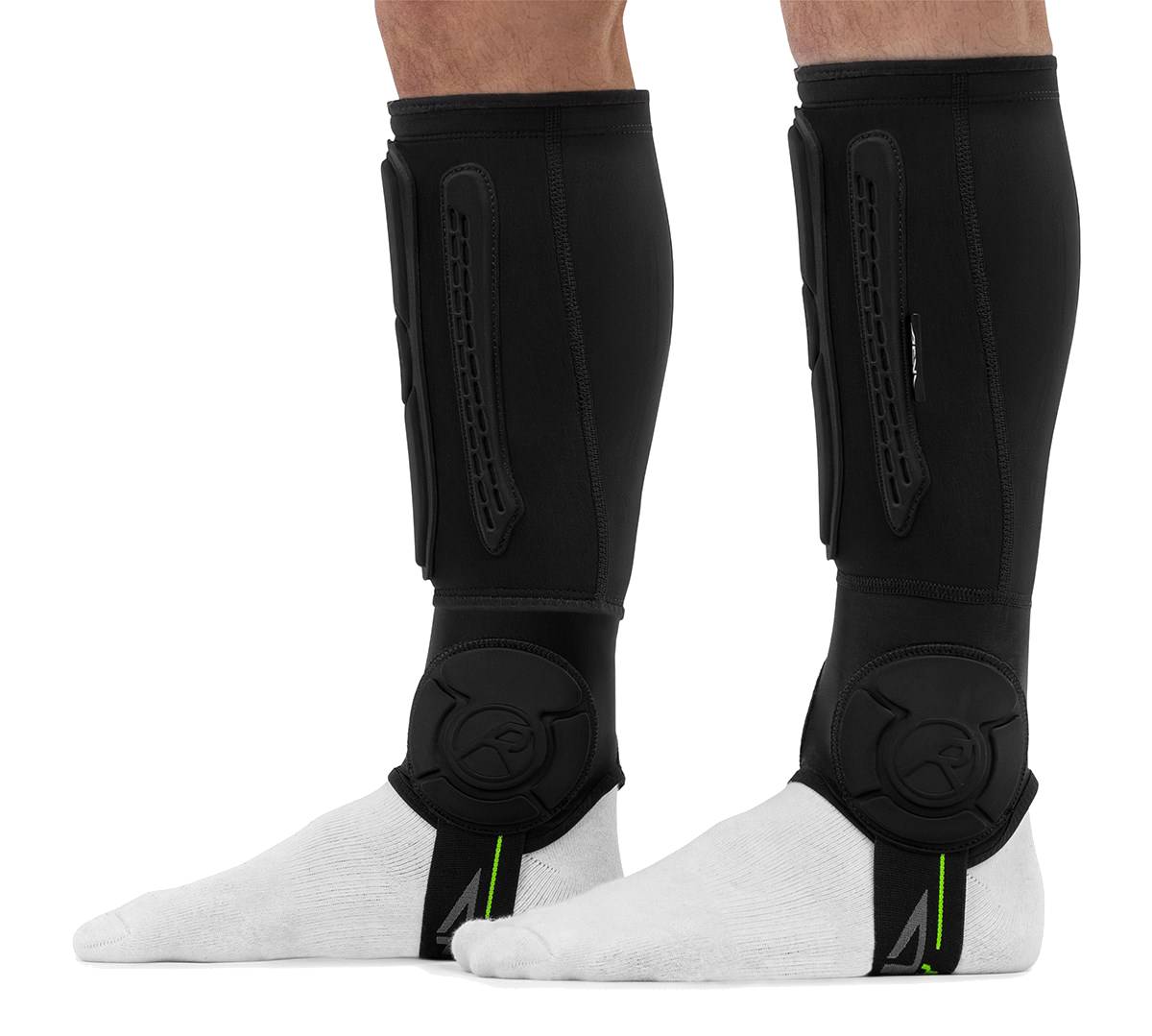 A person wearing black REKD Energy Covert Short Shin and Ankle Skate Protection Guards over white socks for BMX protection.
