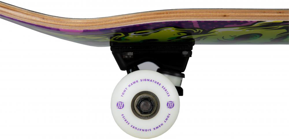 Close-up of a white wheel labeled “Tony Hawk Signature Series” and truck beneath the 8″ x 31.5″ deck of the Tony Hawk 540 Series Slime Complete Skateboard, featuring multicolored artwork by Tony Hawk.