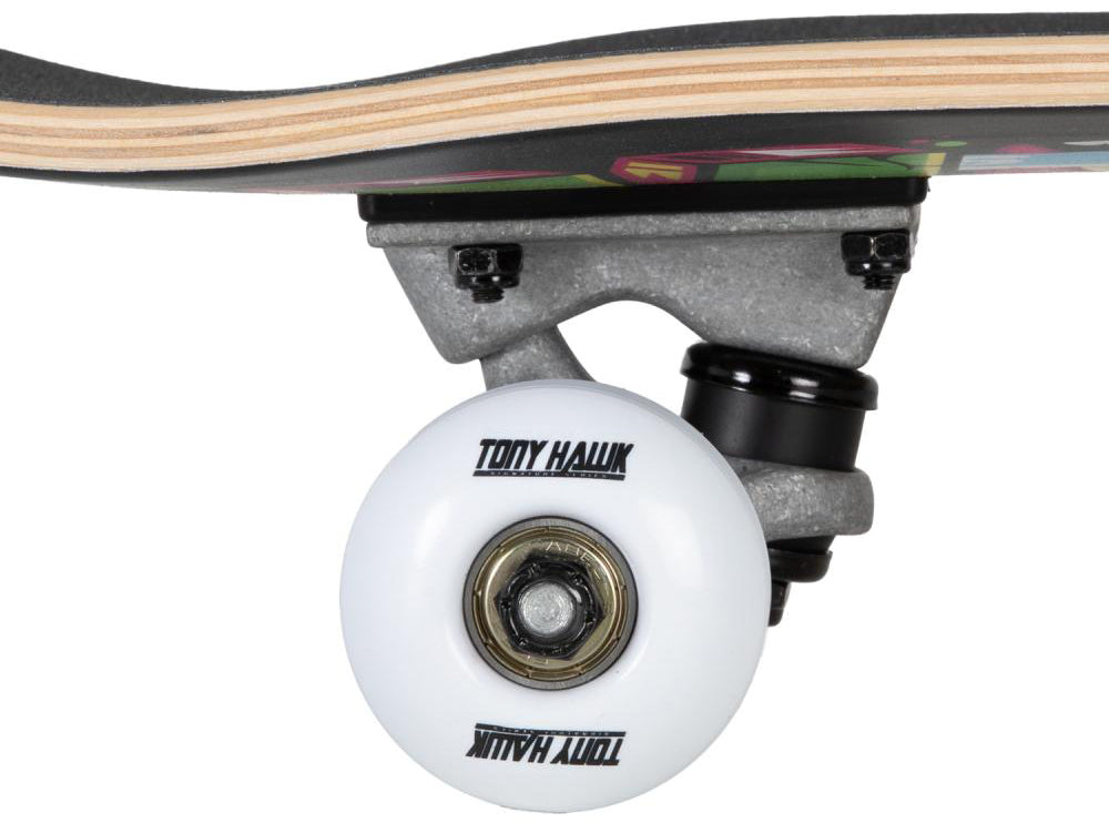 Close-up of a Tony Hawk 180 Series Ransom Complete Skateboard wheel with “Tony Hawk” branding, attached to a metal truck, with part of the 8″ x 31.5″ skateboard deck visible above.