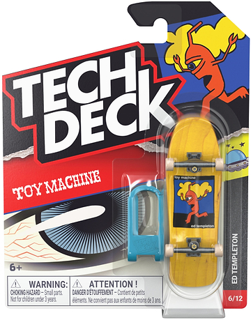 A Tech Deck 96mm M61 Fingerboard - Toy Machine Ed Templeton in its packaging, featuring a yellow deck with an orange monster graphic and a blue plastic assembly tool.