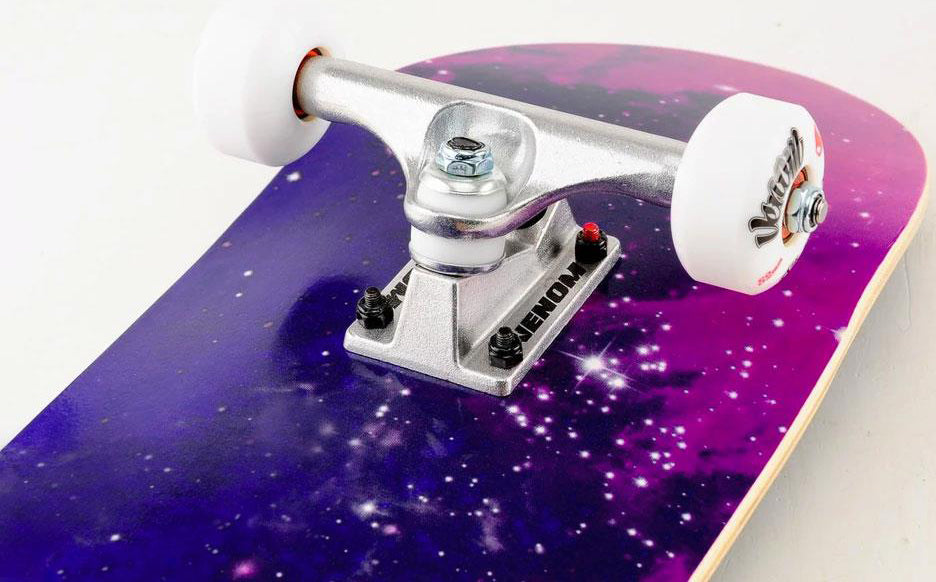 Venom Core Galaxy Complete Skateboard - 7.75″ x 31.75″ featuring a purple and pink galaxy graphic on a maple deck, equipped with silver trucks and white wheels.