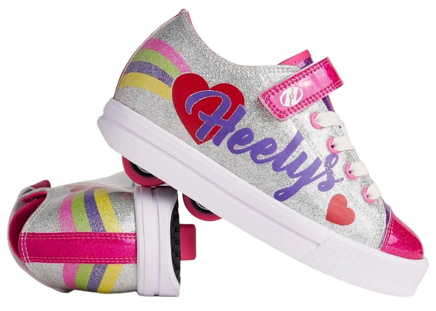 Heelys Snazzy X2 Girls Shoes by Heelys feature a sparkly silver design with rainbow stripes, heart accents, pink laces, and pink wheels in the soles.