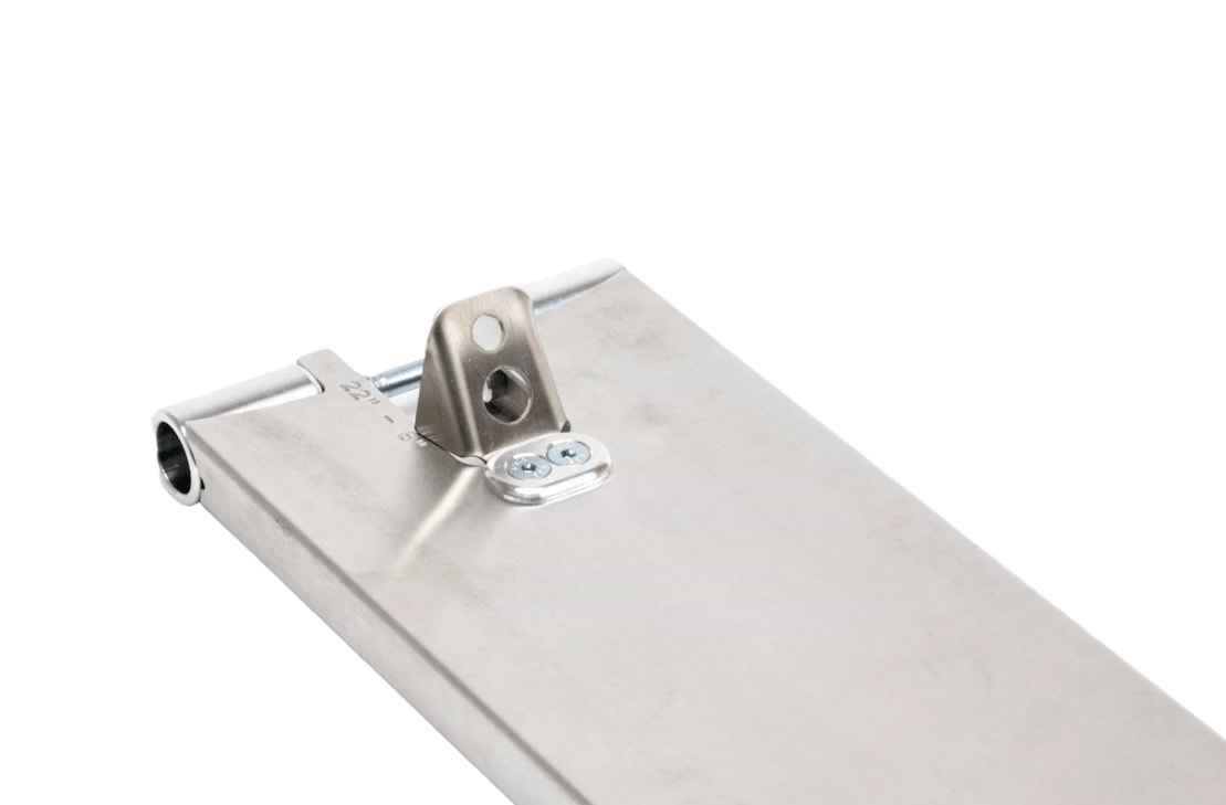A close-up view of a metallic object with a slight sheen, featuring a bracket with two screws and a hole, likely part of the durable Apex Pro Raw Silver Boxed Stunt Scooter Deck - 6" x 21". The background is white and empty, highlighting the object's details.