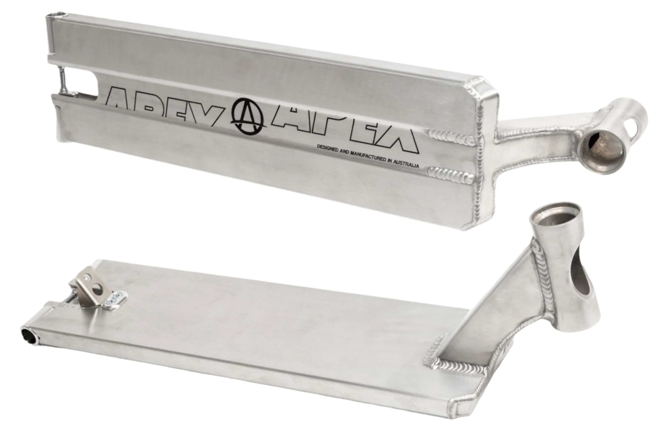 Two Apex Pro Raw Silver Boxed Stunt Scooter Decks, each measuring 6 inches in width and 22 inches in length, feature welded seams. One deck is displayed flat while the other is upright, both highlighting intricate cutouts and a circular cutaway with "APEX" etched on the side. Made from durable brushed metallic finish, these decks exemplify the quality of the Apex brand.