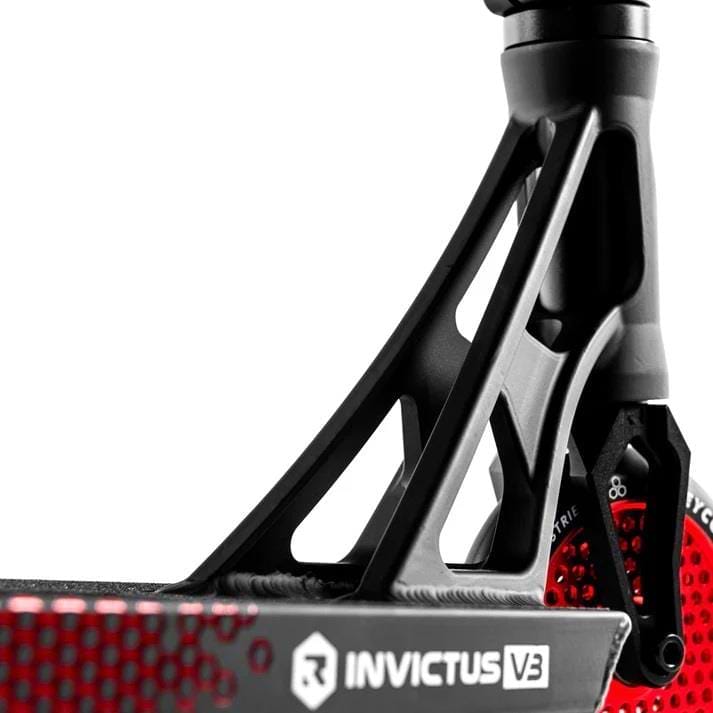 Close-up of the Root Industries Invictus V3 Complete Stunt Scooter - Burnt Red, showing its black deck with red accents, "INVICTUS V3" on the side, part of the wheel, and sturdy support above the deck.