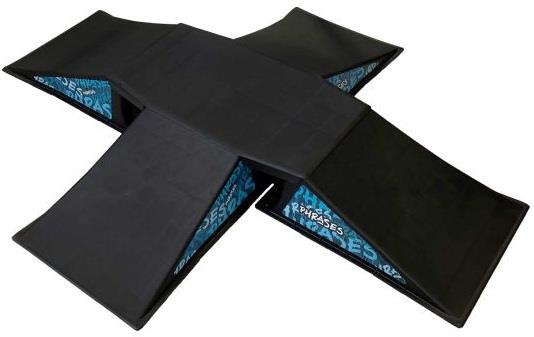 The Phrases Four Way Kicker Skate Ramp is a black, X-shaped foam mat with four inclined ramps meeting at the center and blue patterned material on the inner sides—ideal for skateboarders and scooter riders.