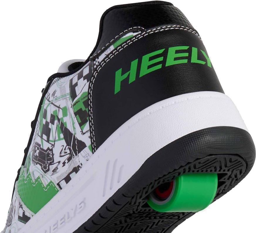 A close-up of the heel of the Heelys x Minecraft Kama Boys Shoes in white, black, and green shows a green wheel in the sole and bold green "HEELY" branding on the black heel.