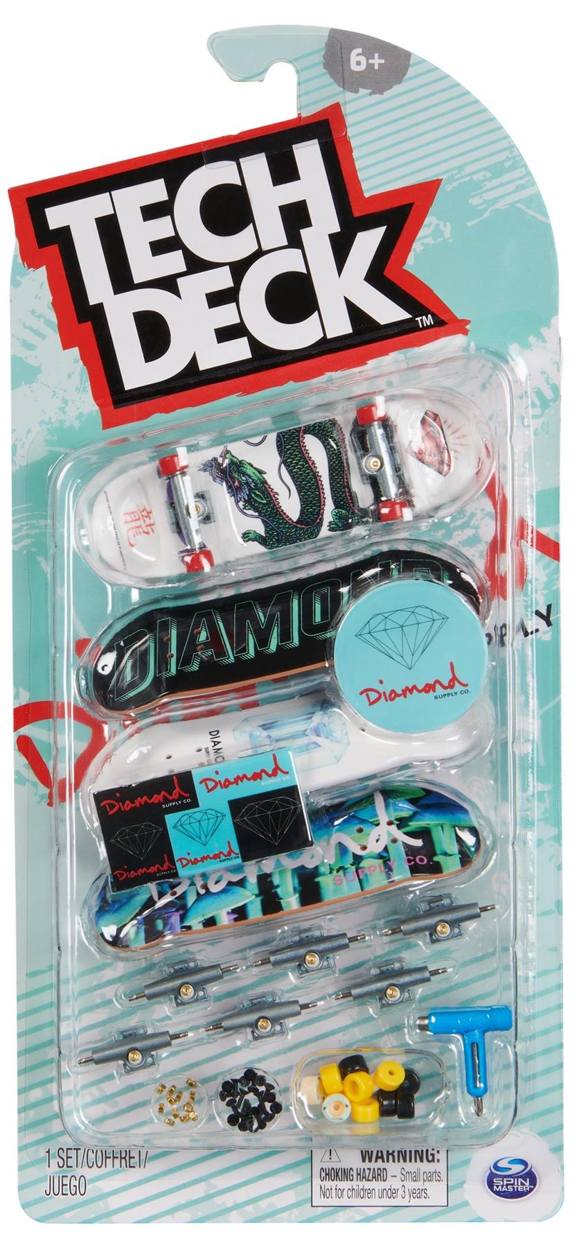 The Tech Deck M01 Deluxe 4 Pack Fingerboards - Diamond includes four authentic fingerboards, tiny wheels, tools, stickers, and a Diamond case for ages 6+, all in clear packaging.