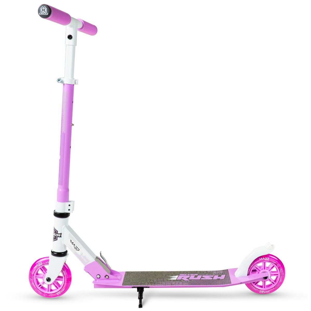 The Madd Gear Metro Rush 125 Kids Foldable Scooter in White/Purple by MGP stands upright on its kickstand, featuring an adjustable handlebar, foldable design, black grip tape, and vibrant wheels against a white background.