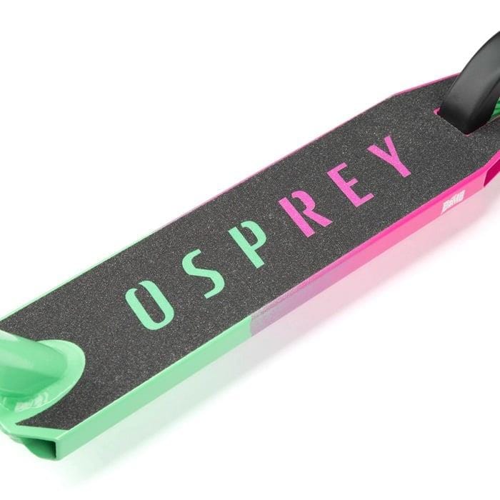 Close-up of the Osprey Bomb Complete Stunt Scooter deck by Osprey, featuring a black grip surface and bold branding. Its pink and green gradient design is ideal for beginner riders wanting both style and control.