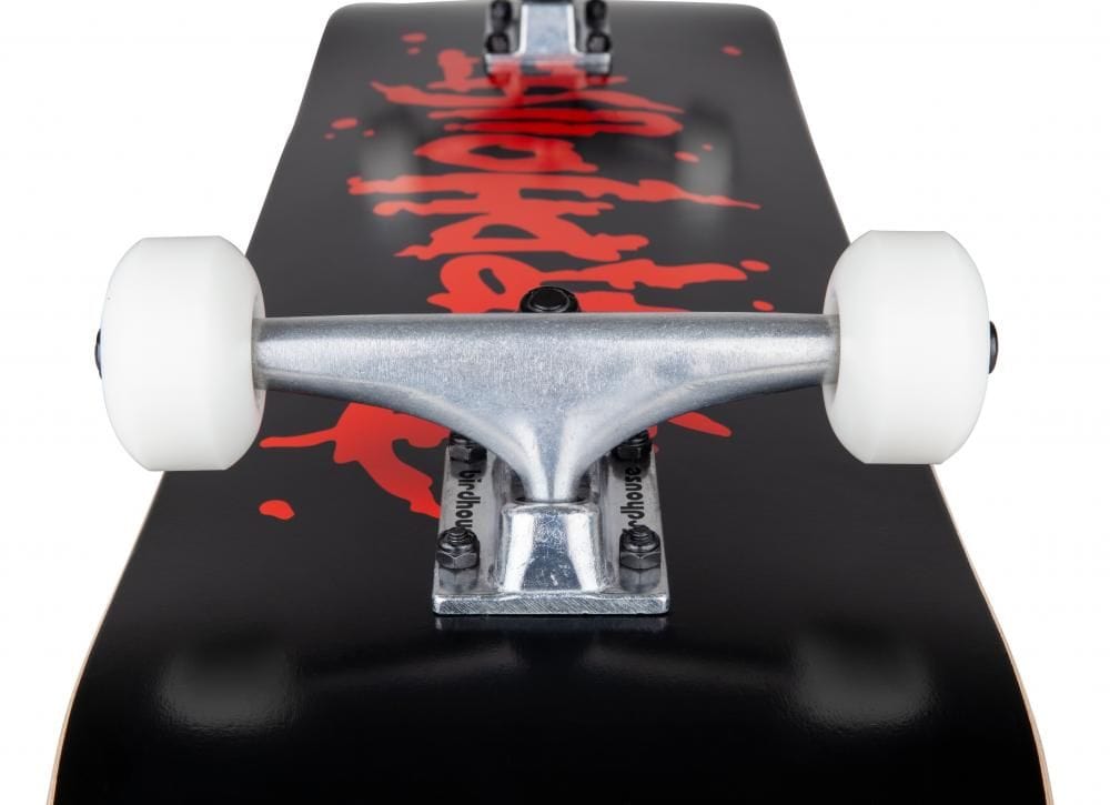 Close-up of a Birdhouse Stage 1 Blood Logo Black Complete Skateboard measuring 8" x 31.5", highlighting its silver trucks, white wheels, and black deck adorned with red graffiti-style writing. The emphasis is on the skateboard's hardware and vibrant design, making it ideal for beginner-friendly skating.