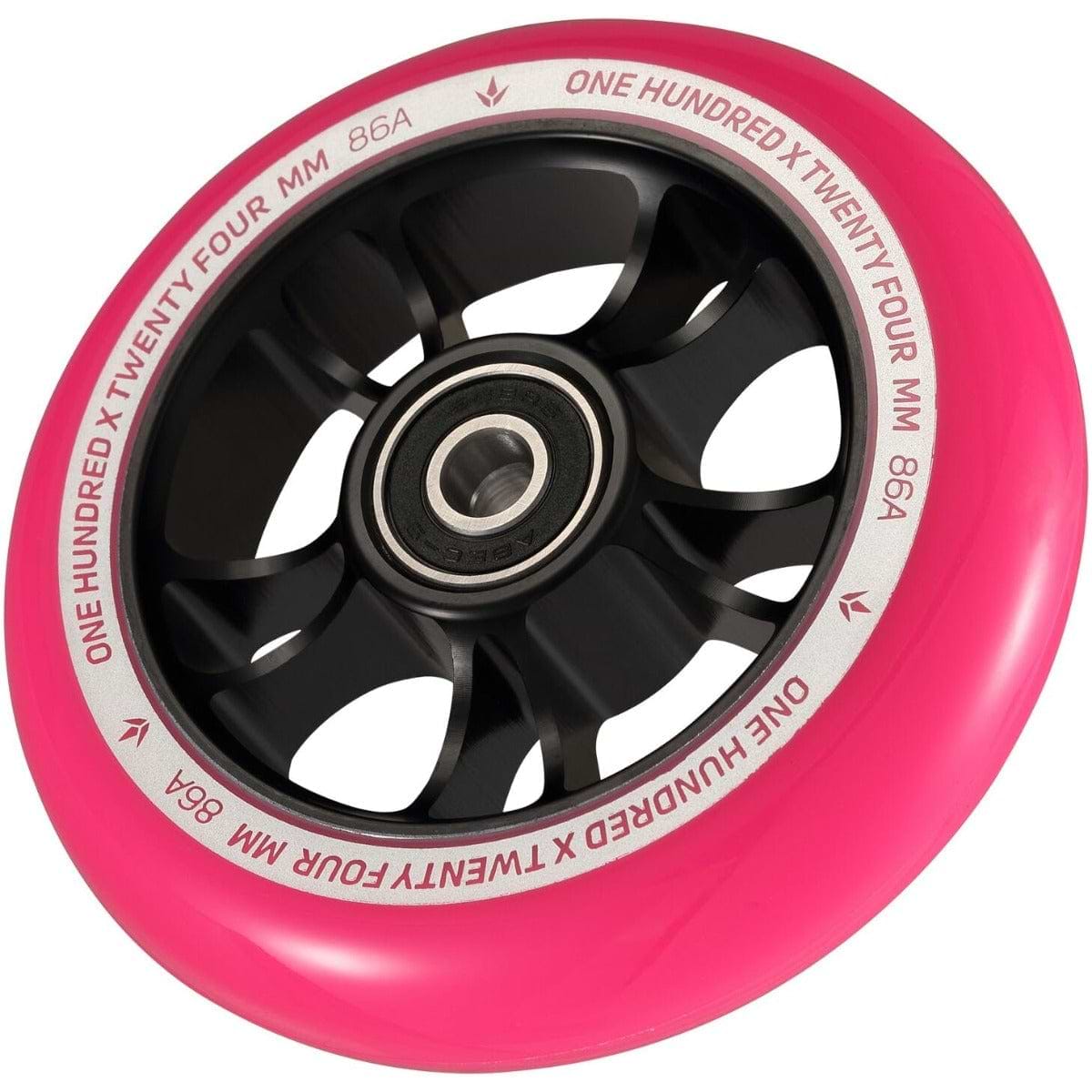 A detailed image showcasing a Blunt Envy 100mm Stunt Scooter Wheel in black and pink. The text "ONE HUNDRED X TWENTY FOUR MM 86A" is prominently displayed along the pink outer edge. This wheel, designed by Blunt Envy, boasts a robust aluminum core and ABEC 9 bearings for optimal performance.