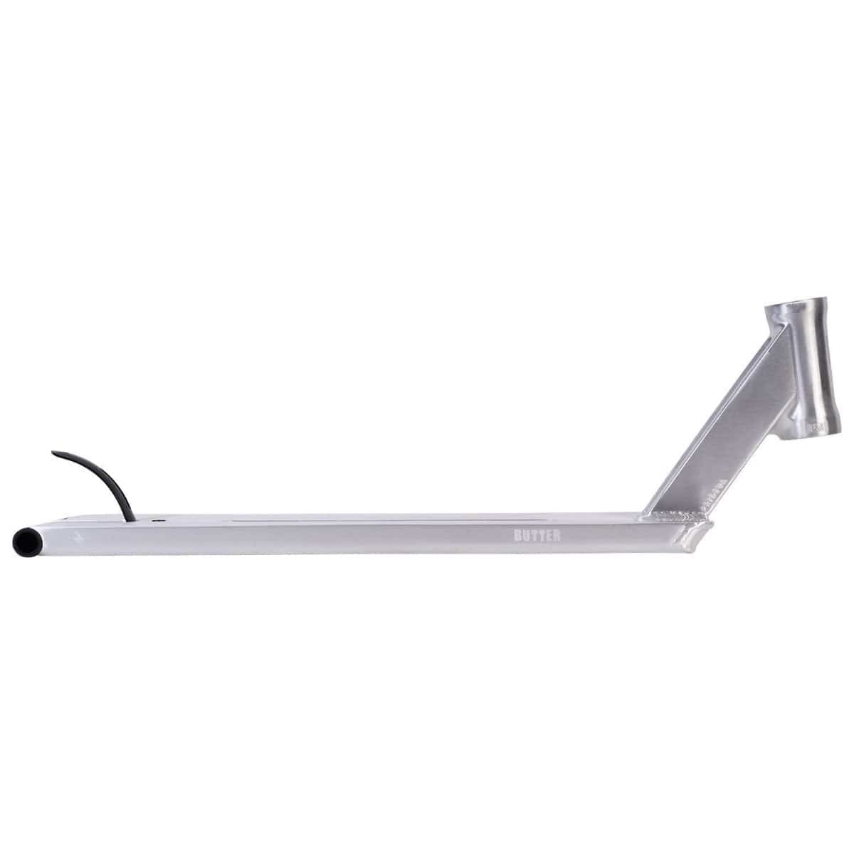 A side view of the UrbanArtt Butter Raw Brushed Silver Stunt Scooter Deck, measuring 5.5" x 23", reveals a silver scooter deck with an integrated headtube. Crafted for street riders, it showcases a sleek, rectangular shape with a subtle upward angle at the front and a brake at the rear. The word "BUTTER" is discreetly visible on its side.