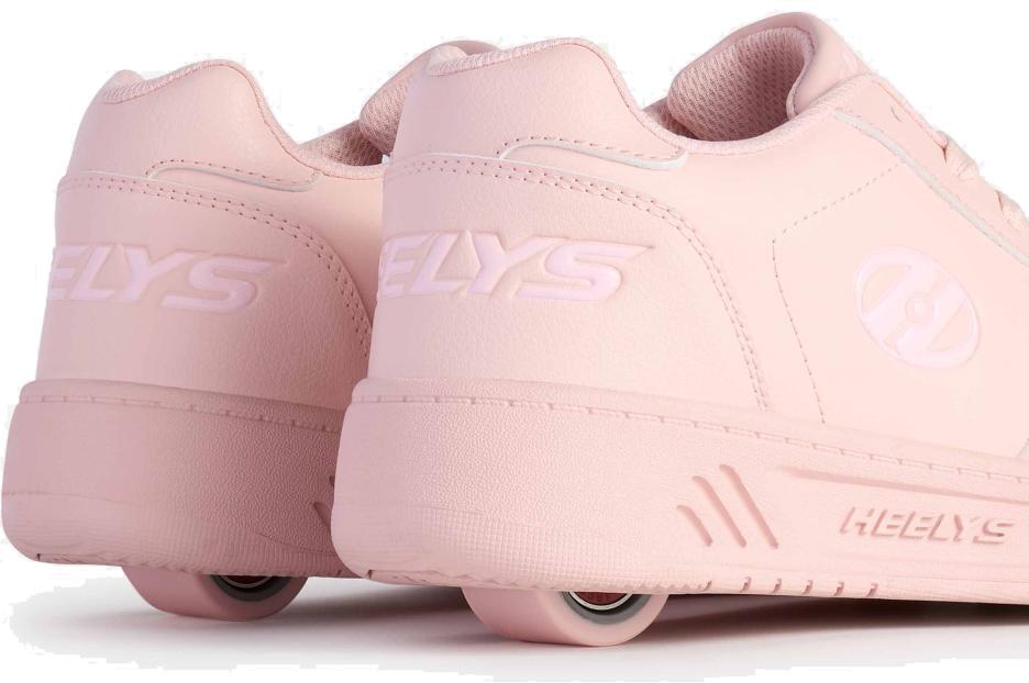 A close-up of Heelys Kama Girls Shoes - Pink shows the Heelys brand and discreet wheels in the soles, combining classic court-style design with playful mobility.