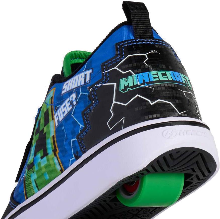 A close-up of Heelys x Minecraft Pro 20 Boys Shoes in black, blue, and green shows a green wheel in the heel, a Creeper-inspired design from Heelys, and "SHORT FUSE!" printed on the side.
