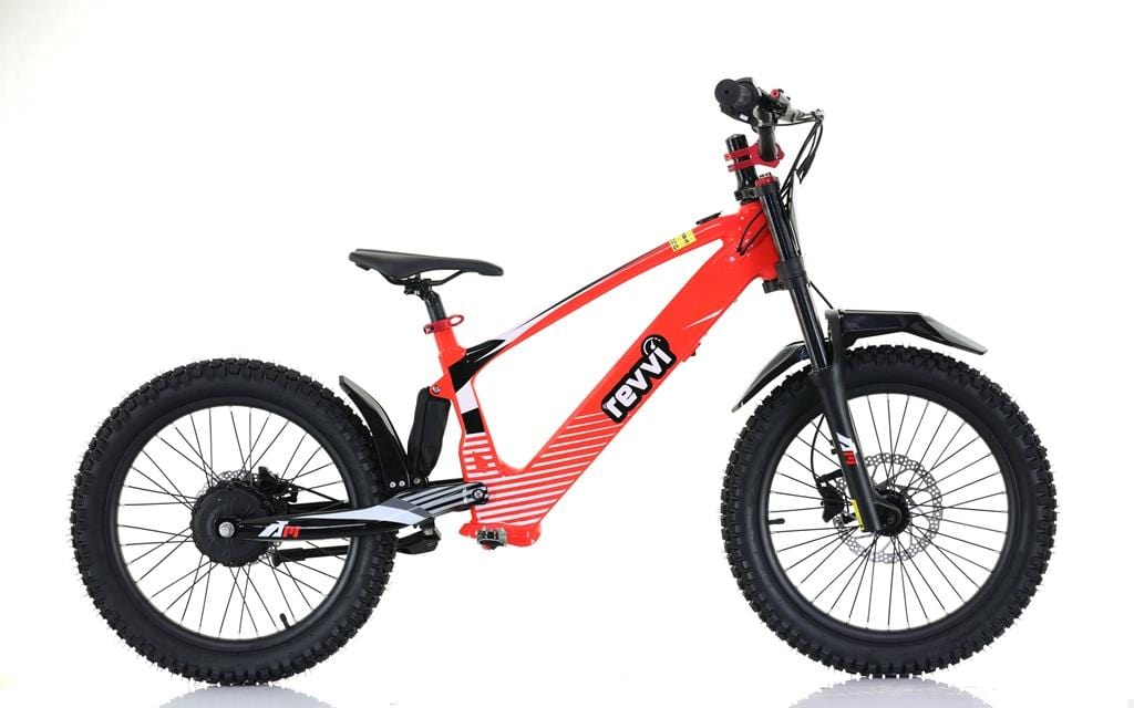 The Revvi 20" Kids Electric Balance Bike - Red features a sleek frame with off-road rubber air-filled tires, proudly displaying the Revvi brand. It includes a front suspension fork and disc brakes for rugged terrains. The background is white.