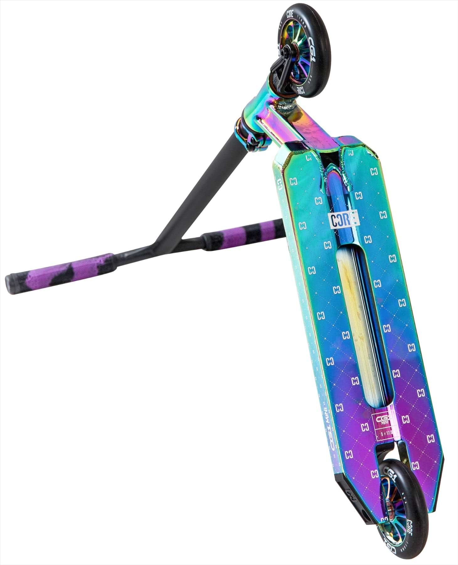 The CORE CG1 Mini Complete Stunt Scooter by CORE features a metallic neochrome finish, black wheels, and handlebars with purple grips. The scooter is shown on its side, displaying the deck's unique pattern and underside.