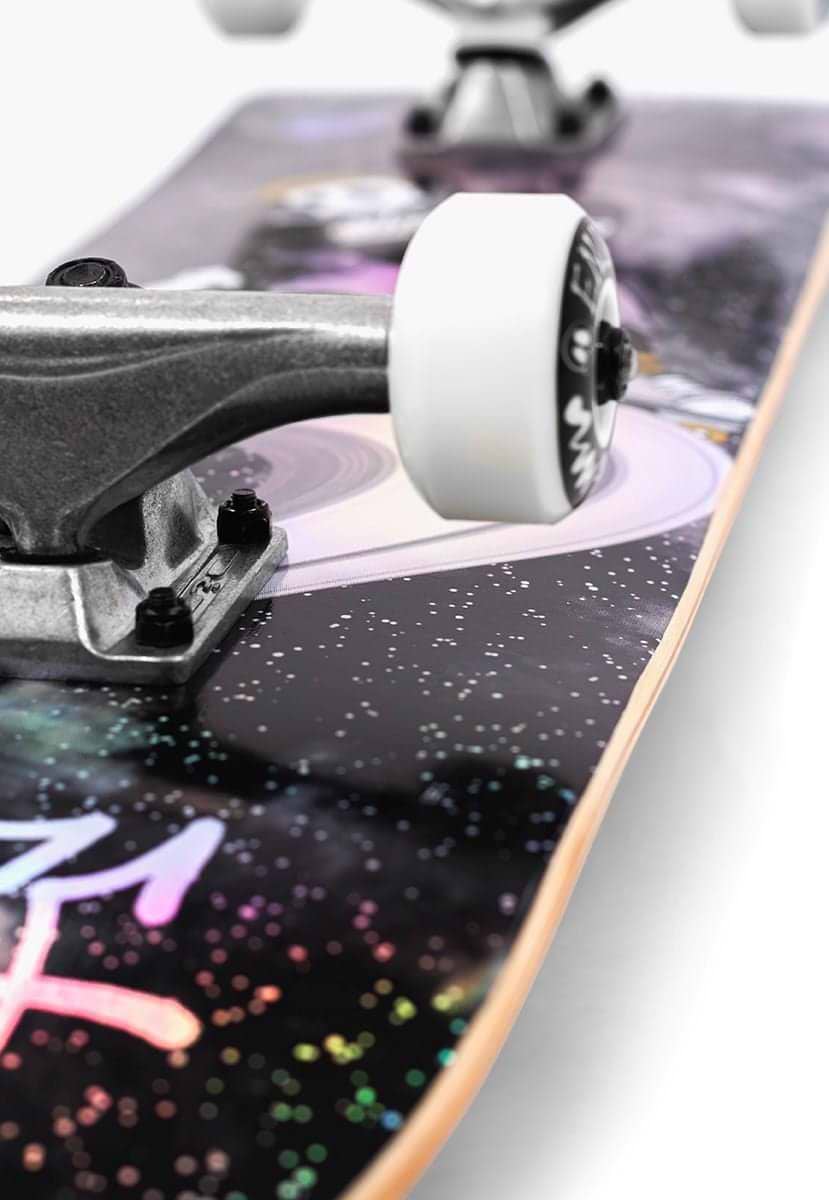 Close-up of the Enuff Skully Hologram Black Complete Skateboard (7.75" x 31.5") with galaxy-themed graphics on the 7-ply maple deck, highlighting white wheels and metal trucks against vibrant cosmic patterns—ideal for beginners.