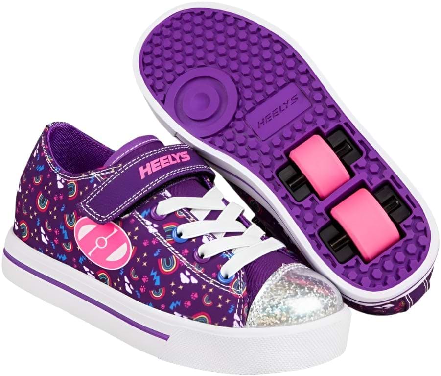 A pair of Heelys Snazzy X2 Girls Shoes by Heelys in purple, multi, and rainbow colors, featuring star patterns, white laces, a sparkling silver toe cap, and pink double wheels visible in the sole of one shoe.