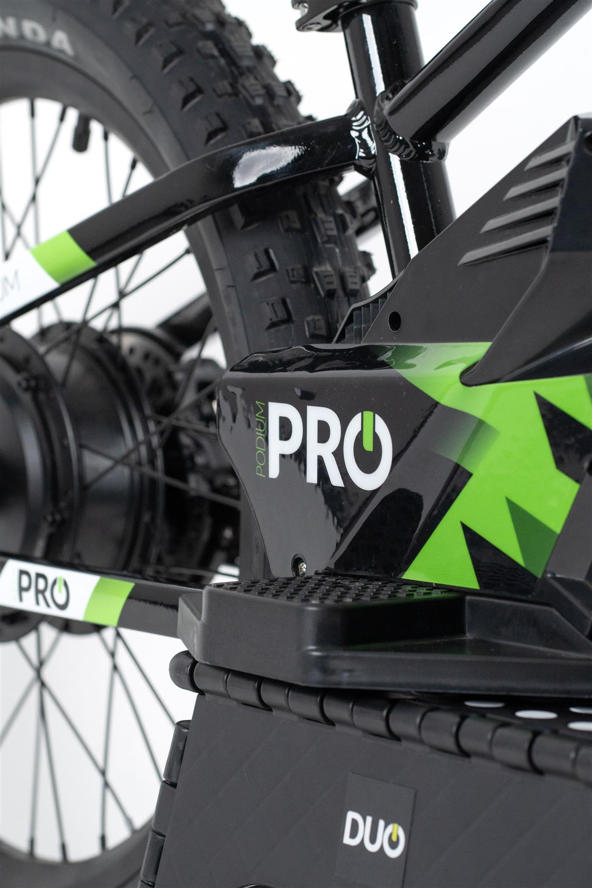 Close-up of the Duo 20" Podium Pro Kids Electric Balance Bike in white and black, highlighting the rear wheel, tire tread, and frame details with "DUO" visible—engineered as a powerful kids' electric motorbike.