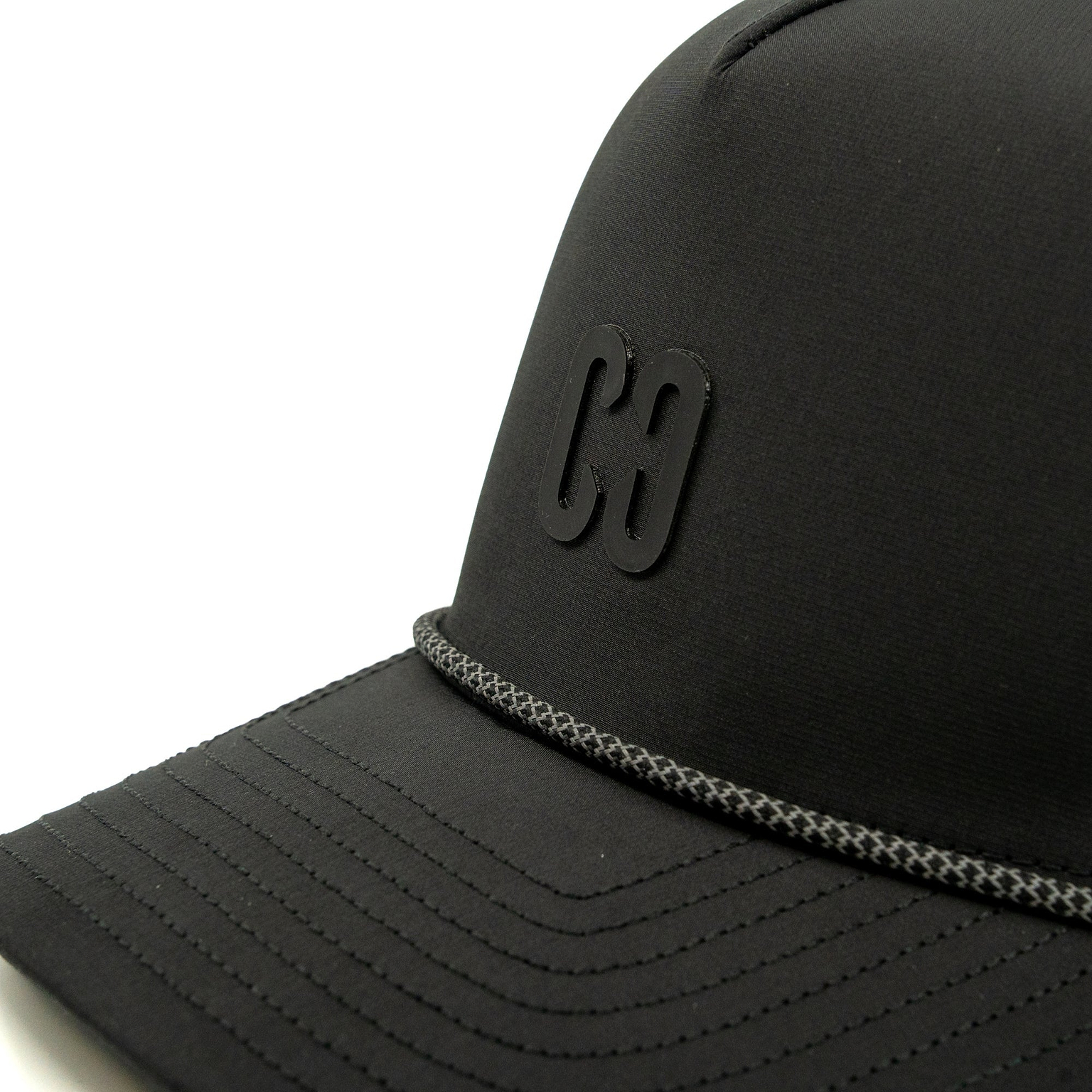 A close-up view of the CORE Aero Rope Cap - Black, featuring a raised “C8” logo and a decorative gray braided rope above the brim.