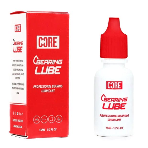 The red and white packaging for the CORE Bearing Lube 15ml Bottle emphasizes its function in bearing maintenance. On the left, a rectangular box provides information about the professional skate lubricant, while on the right, the small bottle with a red dropper cap underscores "Professional Bearing Lubricant" to ensure optimal performance.
