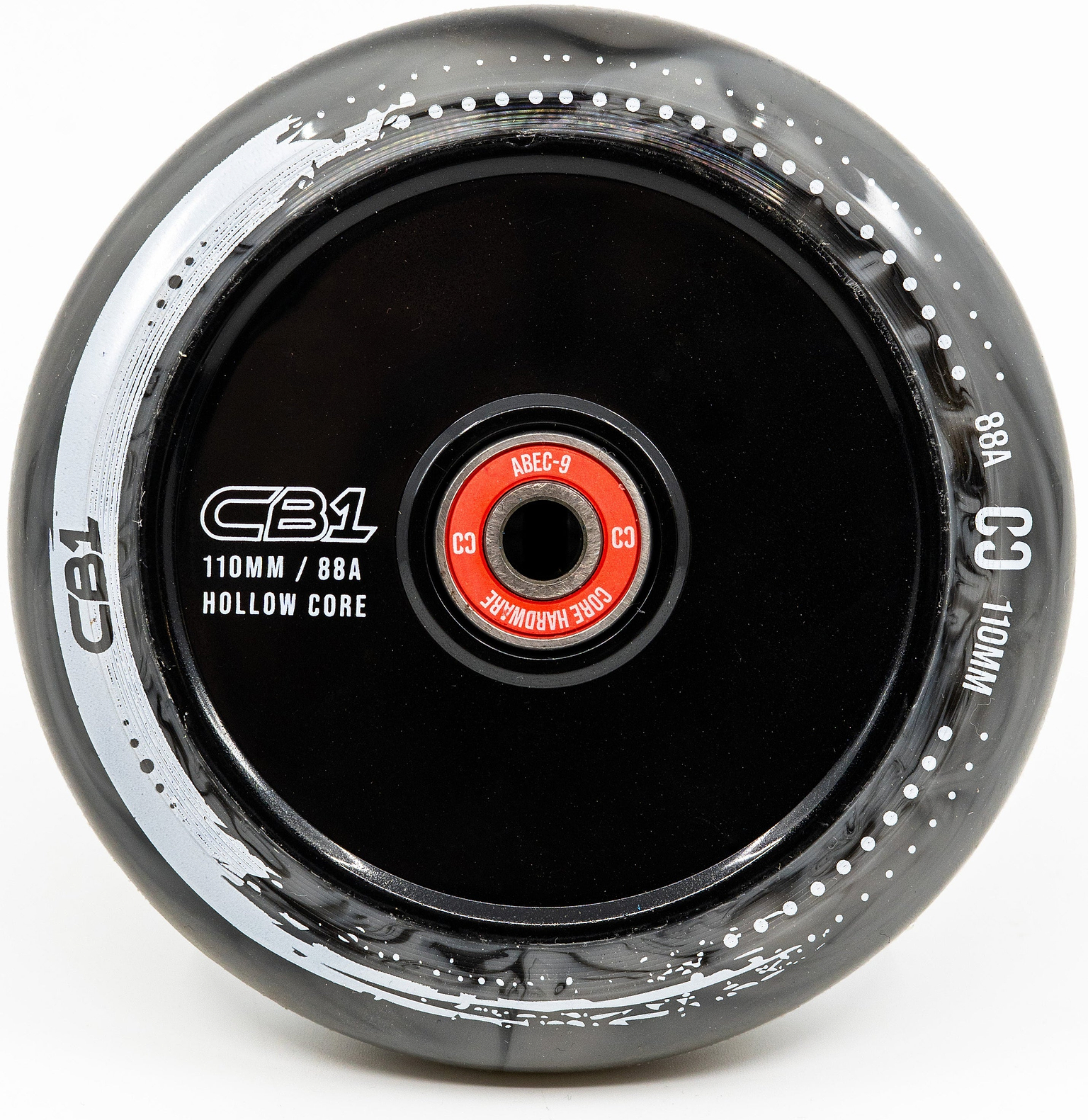 A close-up of the CORE CB1 110mm Nylon Scooter Wheel in Black / White, featuring a hollow nylon core, white detailing, and a red ABEC-9 bearing. The wheel is marked 110mm diameter with an 88A hardness from CORE.
