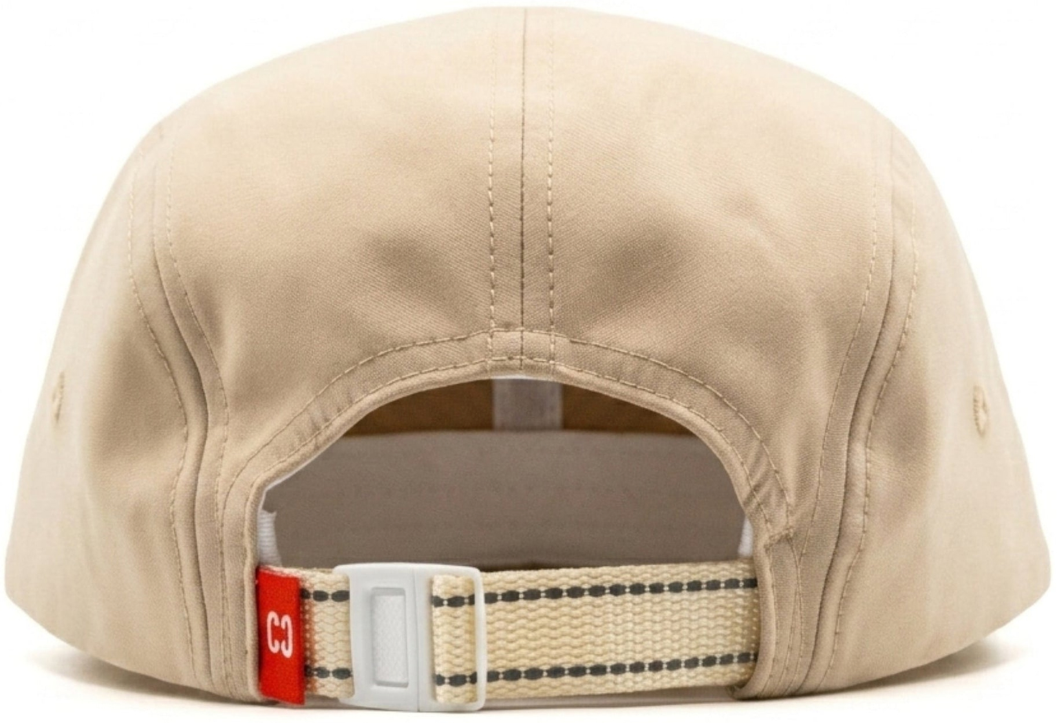 A rear view of the CORE Performance Cap - Sand / Reflective by CORE, showcasing its adjustable strap with a gray buckle and a small red tag displaying the number “3” on the left side. This performance cap is made from breathable fabric to provide enhanced comfort during wear.