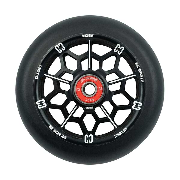 A detailed view of the CORE Hex Hollow Core 110mm Stunt Scooter Wheel in black and red, featuring a unique geometric spoke design. The wheel is marked with "CC" and "High Hollow Tech" on the outer rim and includes ABEC 9 Bearings. The red central hub proudly displays "Core Hardware.