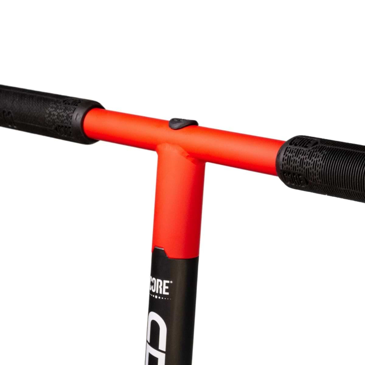 A close-up of the CORE CD1 Complete Stunt Scooter handlebar, featuring red handlebars with black grips, perfect for beginner riders. The aluminium deck stem is partially visible, showcasing a modern and sleek design against a white background.