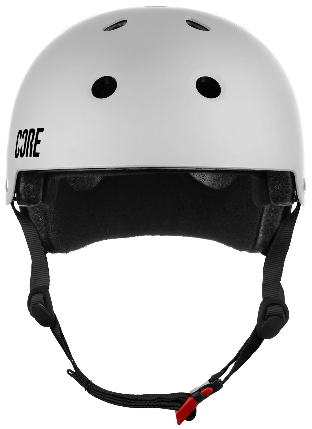 The CORE Street Skate / Scooter Helmet - White by CORE is shown from the front, featuring ventilation holes, black interior padding, an adjustable black strap with a red buckle—ideal for safe and stylish street skating.