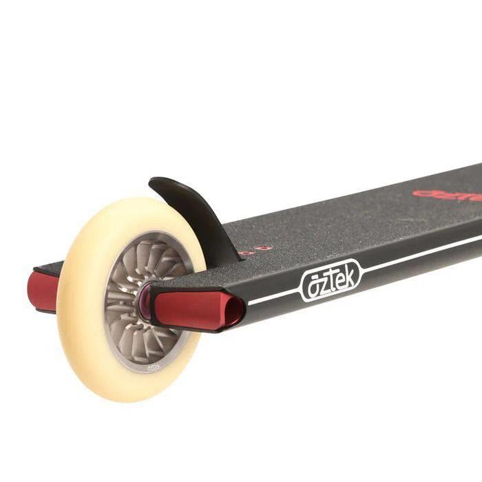 Close-up of the rear wheel and deck of the Aztek Fountain Complete Stunt Scooter in black, featuring a cream-colored wheel, metal brake, and textured deck surface.