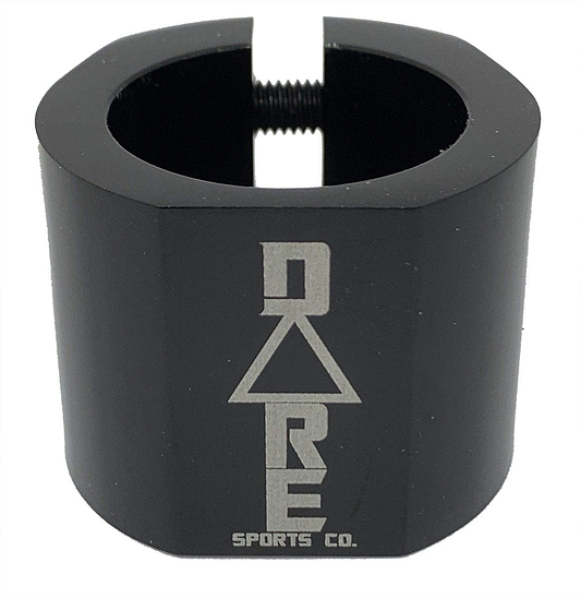 The Dare Warlord 2 Bolt Standard Stunt Scooter Clamp in black, crafted by Dare, is a CNC machined, lightweight metal clamp featuring a hexagonal shape with an engraved "Dare" name and a slit for tightening. It offers exceptional grip and durability, making it perfect for extreme sports enthusiasts.