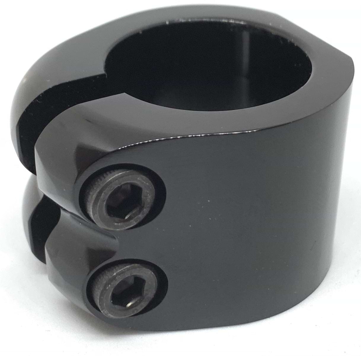 An up-close photograph showcases the Dare Warlord 2 Bolt Standard Stunt Scooter Clamp in black, made by Dare, featuring two hexagonal socket screws and a circular opening with CNC machined precision. This lightweight clamp is perfect for securely fastening or connecting parts in stunt scooter or industrial uses.
