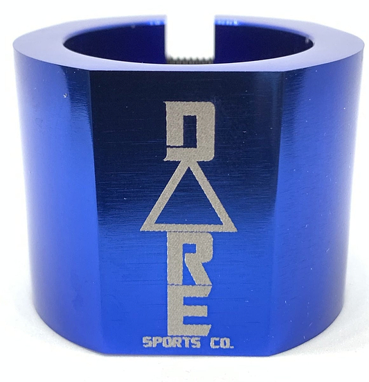 The Dare Warlord 2 Bolt Standard Stunt Scooter Clamp by Dare, in a striking blue metallic finish, is crafted from robust 6061 T6 aluminium and showcases the "DARE SPORTS CO." branding engraved in silver, featuring an innovative triangular design integrated into the lettering.