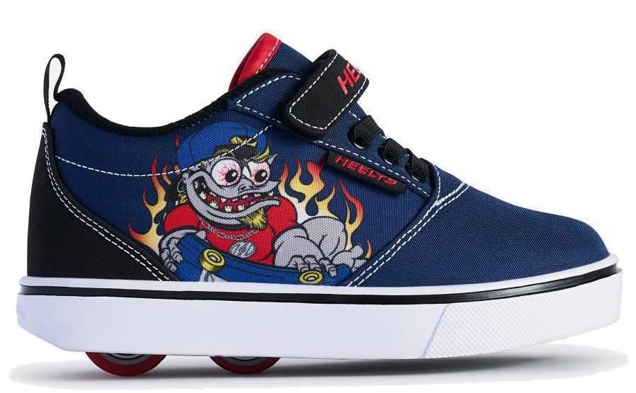 The Heelys Pro 20 Prints X2 Boys Shoes in navy and red feature wheels in the sole, a cartoon character with a skateboard and flames, a black "Heelys" strap, and a white sole. Brand: Heelys.