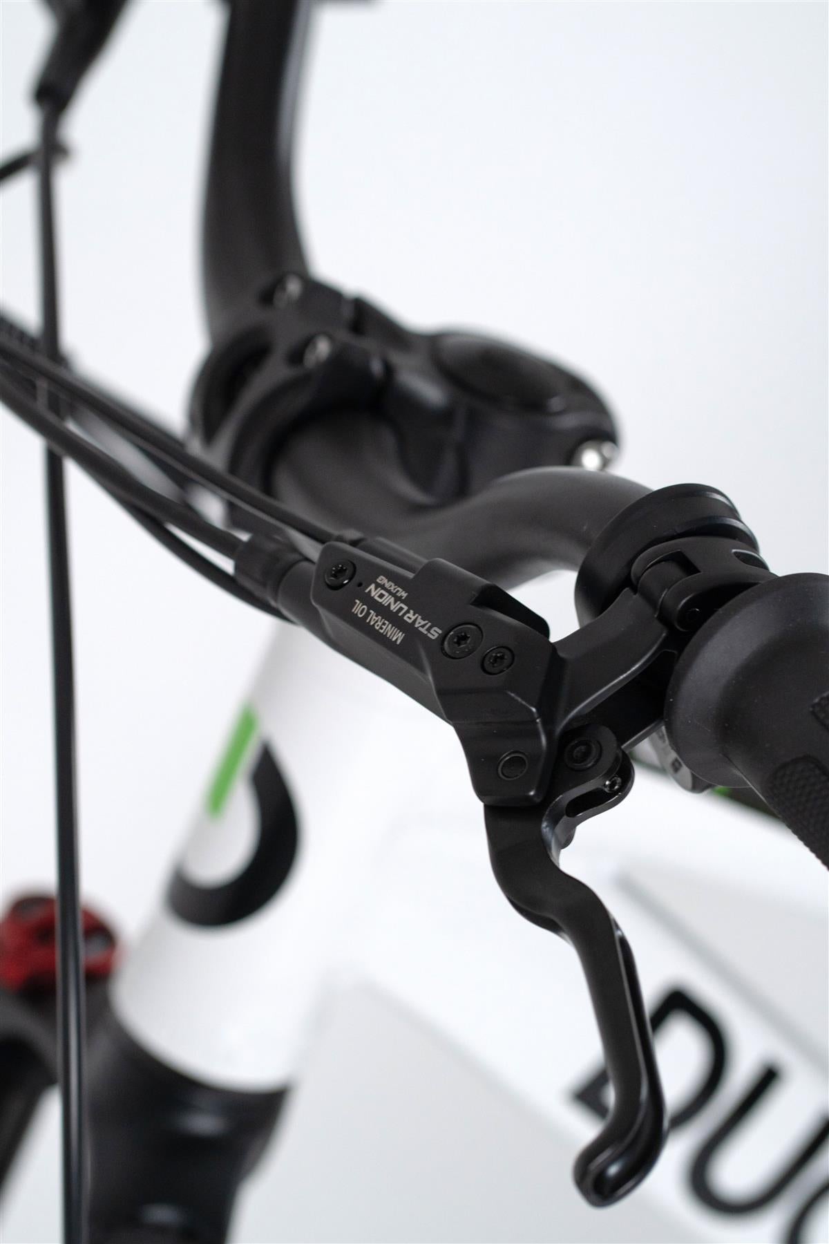 Close-up of the Duo 16" Master Pro Kids Electric Balance Bike’s handlebar and brake lever with visible cables, a partial Duo logo on the white frame, and black grip—ideal for young riders.