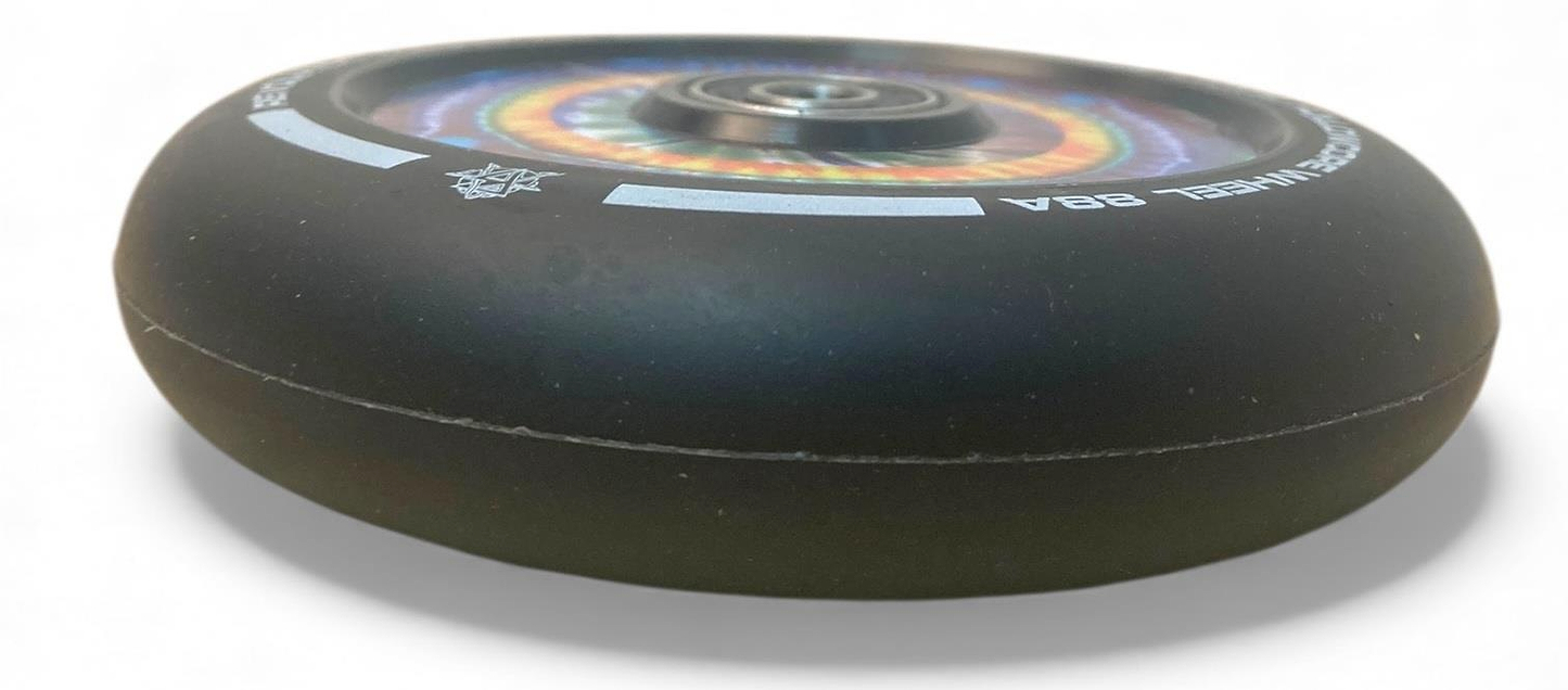 A close-up of the Revolution Hollowcore 110mm Stunt Scooter Wheel—Spanner Jones Signature—by Revolution, featuring a black design, ABEC 9 bearing, and rainbow hub pattern, shown on a white background.