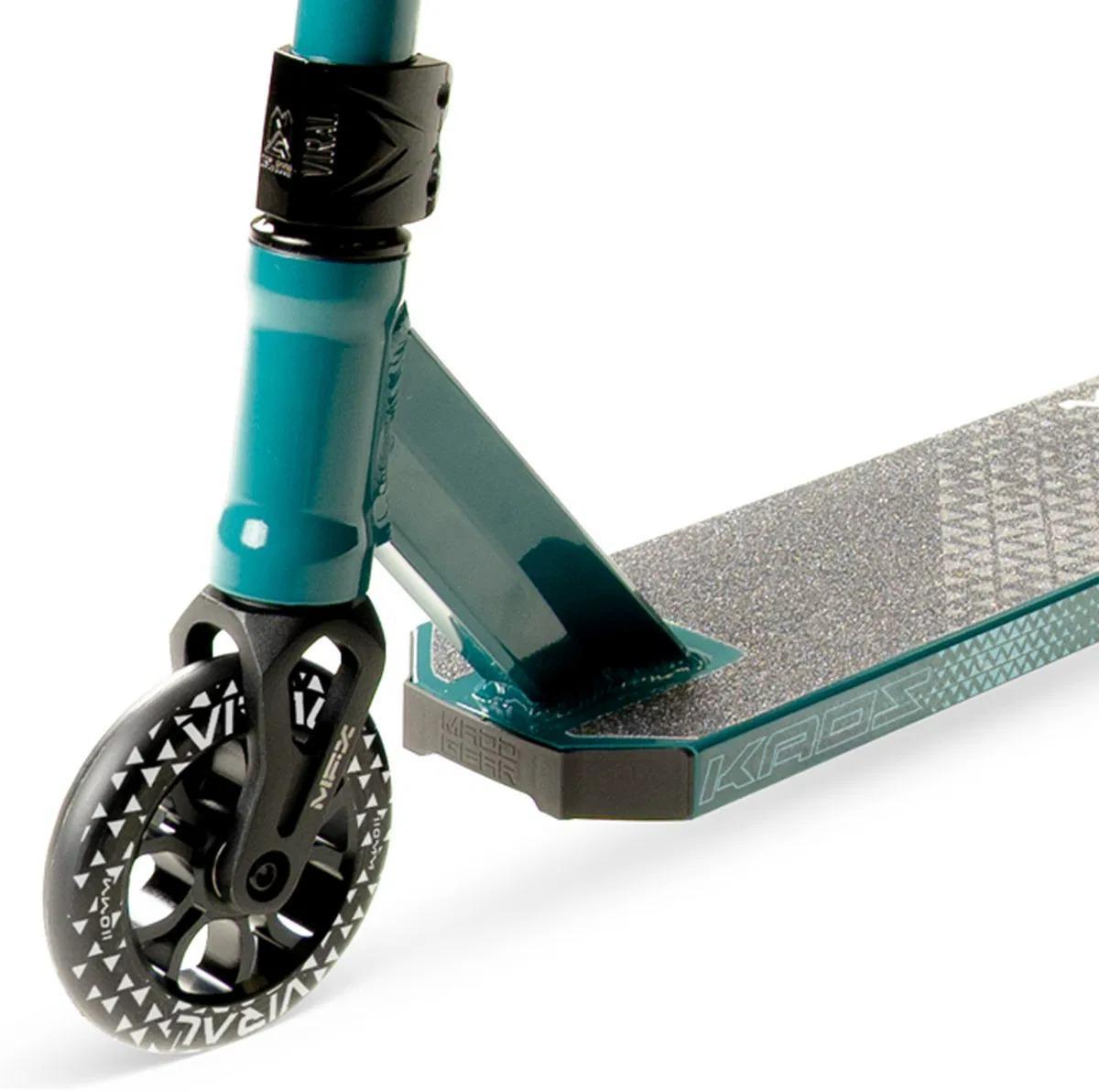 Close-up of the Madd Gear Viral KAOS Complete Stunt Scooter in Denim, highlighting its textured foot deck, sturdy metal fork, and patterned black-and-silver front wheel.
