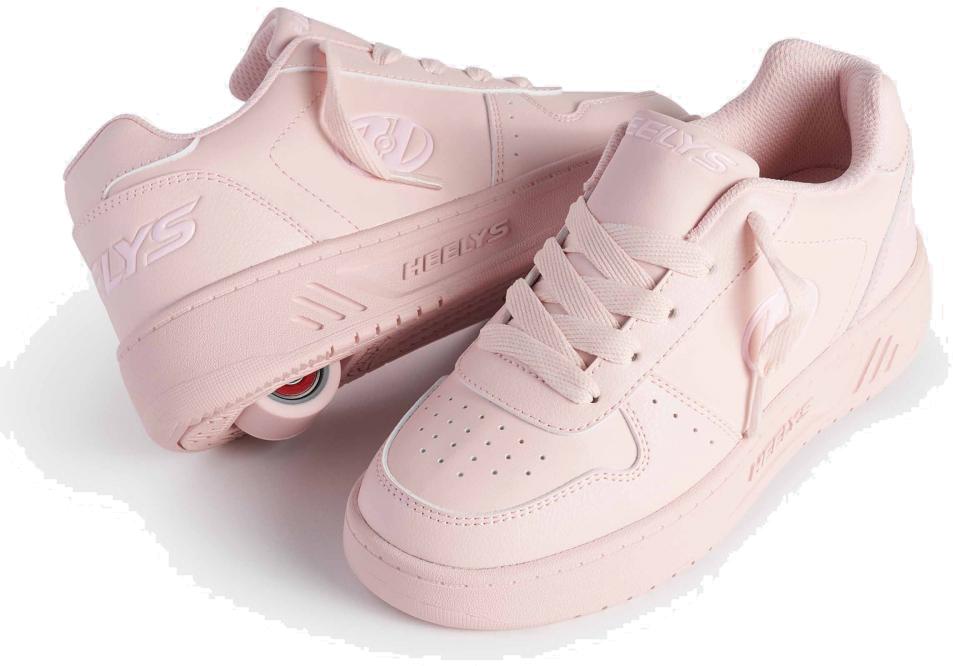 A pair of Heelys Kama Girls Shoes in pink, one tilted to reveal the low-profile wheel in the heel and the other flat, showcasing court-style details and the Heelys brand logo.