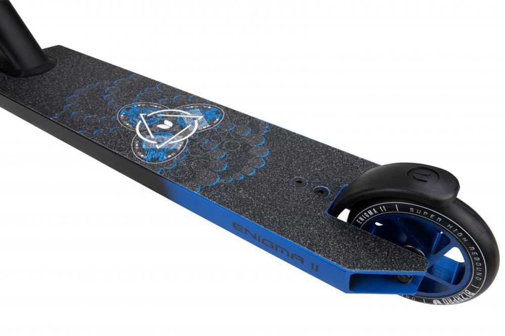 Close-up of the durable deck from the Blazer Pro Enigma 2 Complete Stunt Scooter in black and blue, showcasing a textured surface with an artistic design. The rear wheel is visible, displaying "Super High Rebound" on the tire. Ideal for beginners, the side of the deck is labeled "ENIGMA II.