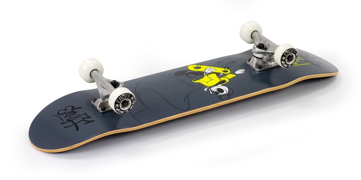 The Enuff Skully Black Complete Skateboard - 7.75" x 31.5" from Enuff features a dark gray deck with a yellow, stylized cartoon character. This entry-level skateboard includes high-quality components like white wheels and silver trucks, all displayed against a clean white background.