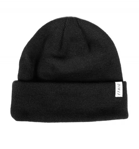 Introducing the Ethic DTC Serpico Beanie in black: a timeless knitted piece that showcases a folded brim and a small tag with the "ETHIC" logo. This cozy and warm beanie from Ethic is ideal for chilly weather, offering both comfort and style.